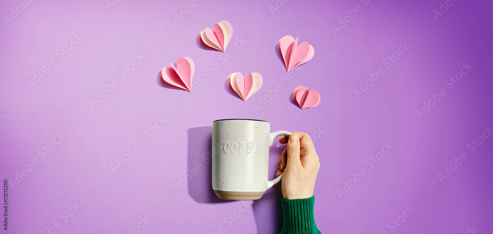 Poster female hand holding a mug with paper craft hearts - flat lay - Posters