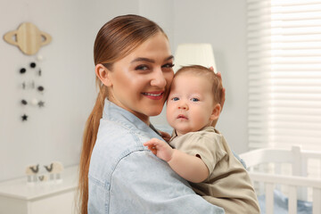 Mother holding her cute newborn baby at home