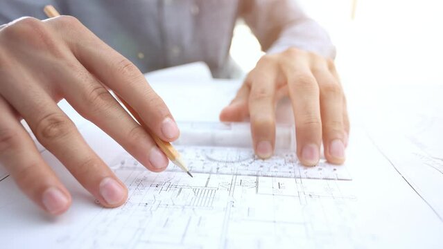 Young handsome architect engineer working on design plan