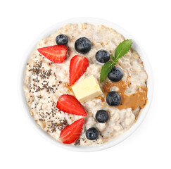 Tasty boiled oatmeal with berries, chia seeds and peanut butter in bowl isolated on white, top view