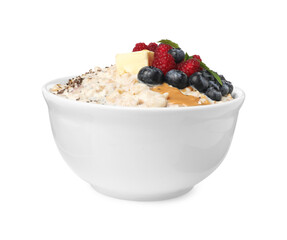 Tasty boiled oatmeal with berries, chia seeds and peanut butter in bowl isolated on white