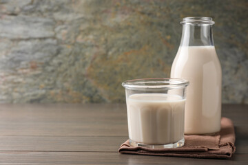 Glassware with lactose free milk on wooden table, space for text