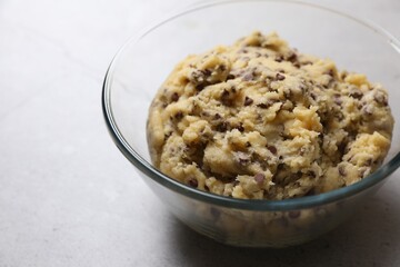 Chocolate chip cookie dough in glass bowl on table, closeup