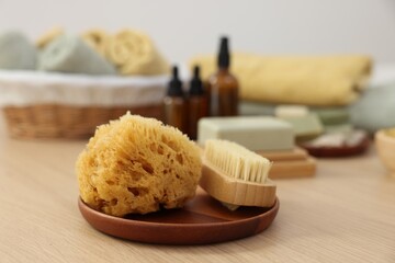 Sponge and brush on light wooden table. Spa therapy