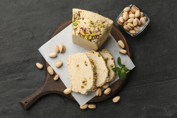 Tasty halva with pistachios and mint on grey table, top view