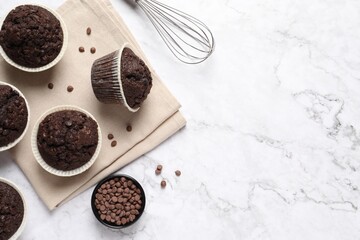 Tasty chocolate muffins on white marble table, flat lay. Space for text