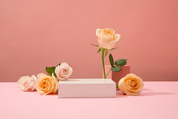 Fresh roses are artistically arranged around the white podium. Ideal space for cosmetics display....