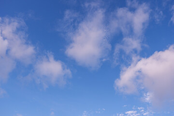 Naklejka na ściany i meble Clear blue sky background with a few white clouds