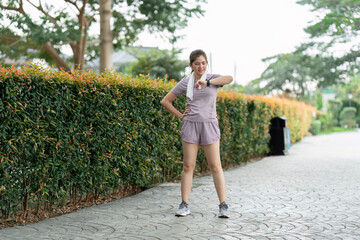 Sport young woman looking at smartwatch on her wrist, tracking fitness activity during training outdoors