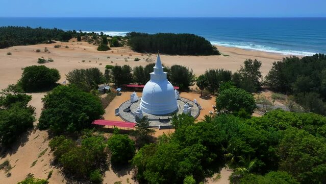 Aerial Panning Shot Of People Exploring Muhudu Maha Vihara At Beach On Sunny Day - Pottuvil, Sri Lanka