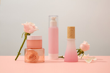 Displayed on platforms, skincare products complemented by fresh roses create an elegant scene. The exquisite pastel background offers a commercial aesthetic with generous copy space.