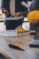 Fototapeta premium A team of construction engineers talks to managers and construction workers at the construction site. Quality inspection, work plan, home and industrial building design project