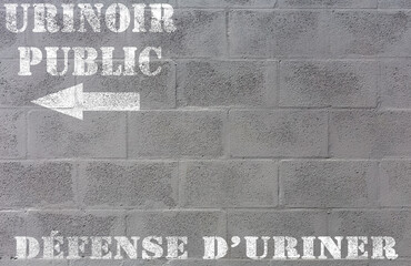 Urinoir public, défense d’uriner, marquage sur mur de parpaings  - obrazy, fototapety, plakaty