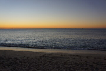 Naklejka premium Beach and ocean just before sunrise, sky turning bright