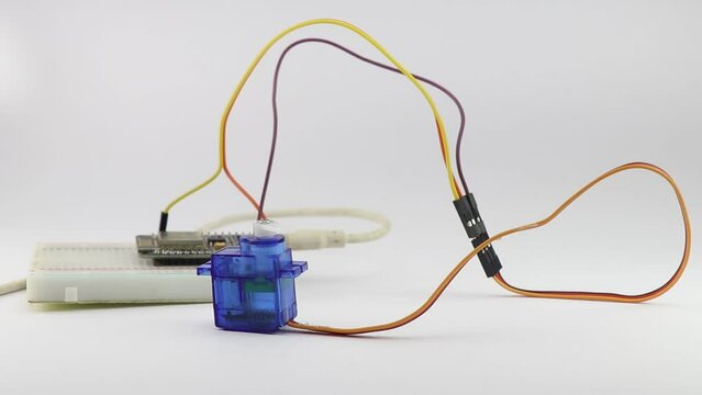 Servo motor connected to a simple breadboard circuit with a programmable micro controller board controlling the movements