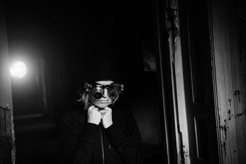 Dramatic black and white photo in the style of steam punk of a blonde girl in steampunk glasses and...