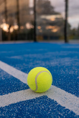 selective focus, blue paddletennis court and one ball on the line at sunset