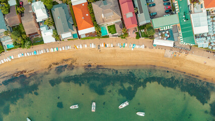 aerial image at a top angle from a drone of the seashore on an Australian beach showing the kayaks...