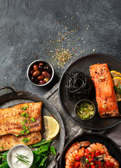 Grilled salmon fish fillet with lemon and strimps. Sea food dishes assorty. Healthy concept