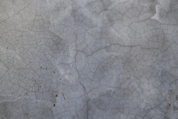 The surface of the vintage concrete wall with cracked paint. Old grey grunge background with texture of wall.