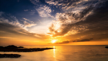 The image captures a serene sunset over the sea, with the sun casting a warm, golden glow across...