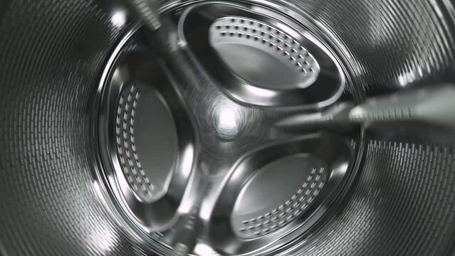 Inside view of the washing machine drum, close-up of the stainless steel drum during the spin cycle.