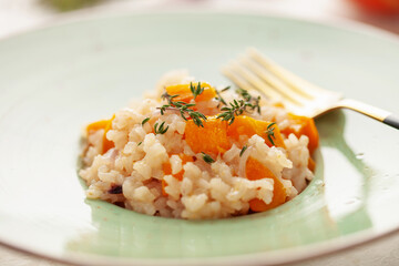 Pumpkin risotto with fresh thyme in plate. Italian Food