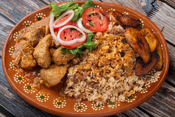 Rice congri with pork fricassee, salad and fried ripe plantain. Typical Cuban food.