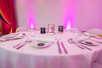 Wedding reception restaurant interiors, tables, plates, glasses and cutlery