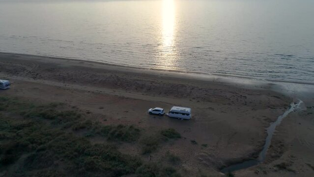 50fps aerial Sunset Couple with dog on Outdoor vacation caravan campsite camper on Melby beach, Sweden by the ocean