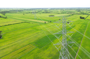 High-voltage power lines crossing a green field in the countryside