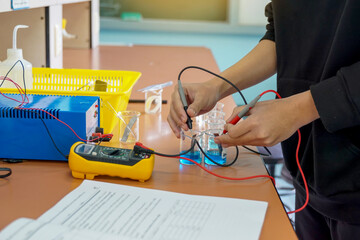 Students use a digital multimeter to measure electrical potential differences in a chemistry...
