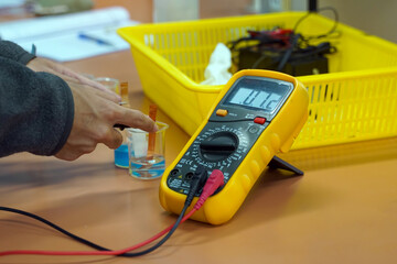 Students use a digital multimeter to measure electrical potential differences in a chemistry...