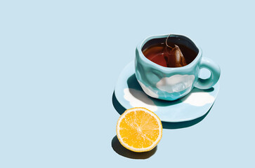 Lemon tea cup with teabag and lemon fruit.
