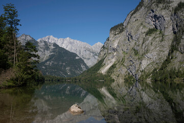 Fototapeta na wymiar View of Obersee in Schönau am Königssee. Reflection of the mountains in the water. Germany, Europe.