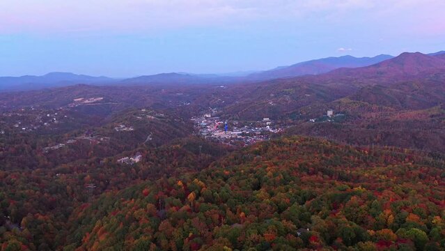 Slow Fly-over of Downtown Pigeon Forge, TN. Pink-Purple Sunset Over the Smoky Mountains with Fall Leaves,