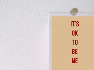 Paper stick on copy space white wall 'Its ok to be me' concept of using positive self-talk...
