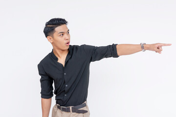 A shocked Filipino man pointing at the right, mouth wide open. Looking for answers. Wearing black polo shirt, isolated on a white background.
