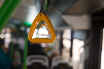 Yellow holder for grip on the bus on the handrail on the ceiling while riding while standing in public transport