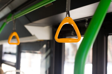 Yellow hanging holder in the bus on the handrail under the ceiling in the shape of a triangle for...