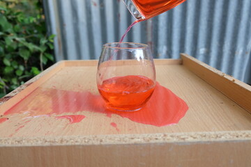 pouring wine into glass on wooden table 