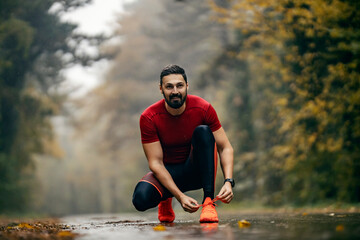A runner is preparing for running in nature in misty and rainy weather.