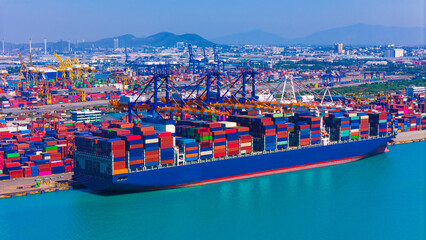 Aerial side view of cargo ship carrying container and running for export goods from cargo yard port...