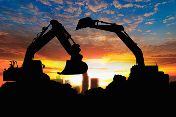 Crawler excavators silhouette are digging the soil in the construction site citys. on sunset...