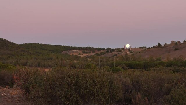 Anochecer con luna llena entre las ruinas de una mina abandonada y berrea del ciervo de fondo.