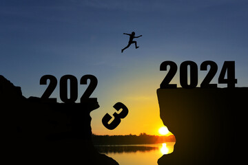 Man jumping 2023-2024. man jumping over cliff on sunset background,Business concept idea