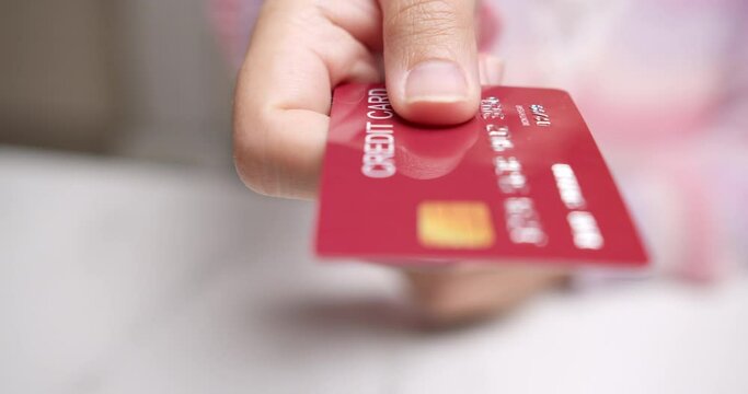Detail of female hands selecting credit card to make purchase