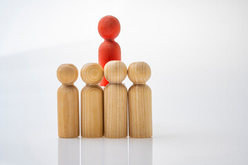 Red wooden figures stand out from the crowd of wooden figures