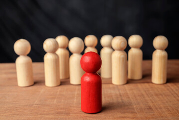 Red wooden figures stand out from the crowd of wooden figures