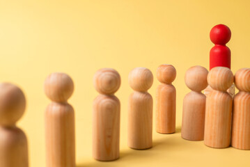 Red wooden figures stand out from the crowd of wooden figures